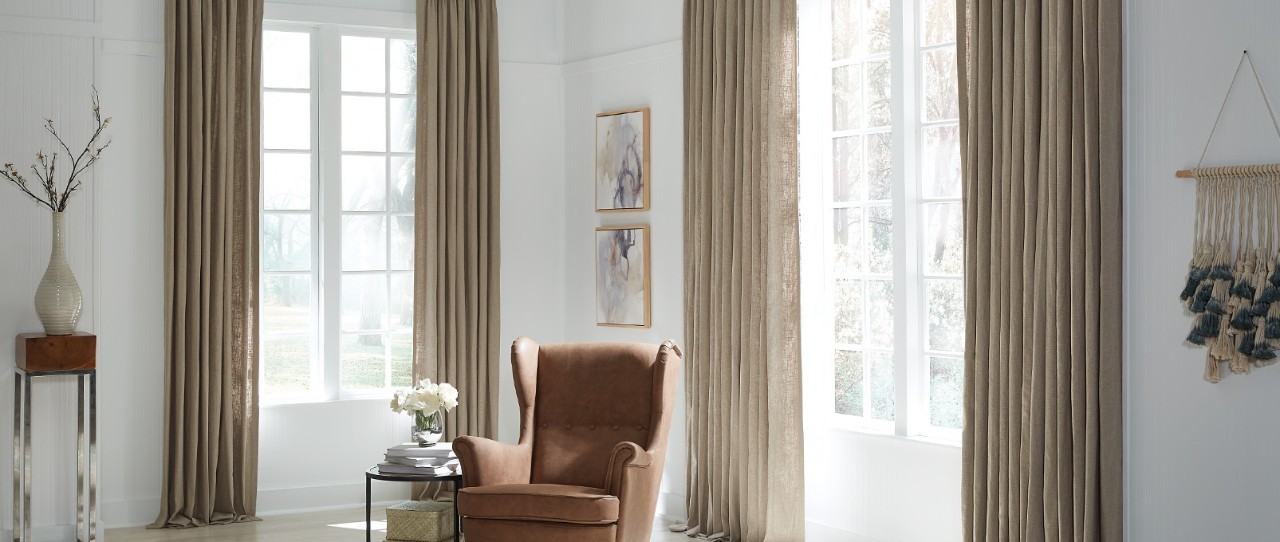Room with white walls and brown fabric curtains. 
