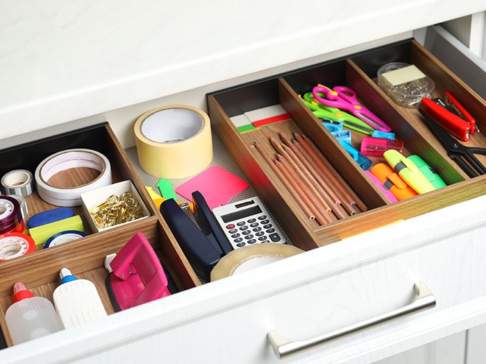 A drawer with dividers for office supplies.